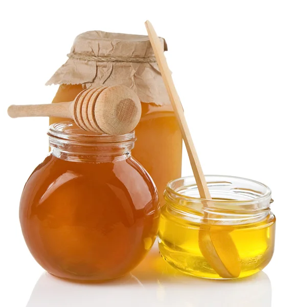 Vaso di miele e bastone isolato su bianco — Foto Stock