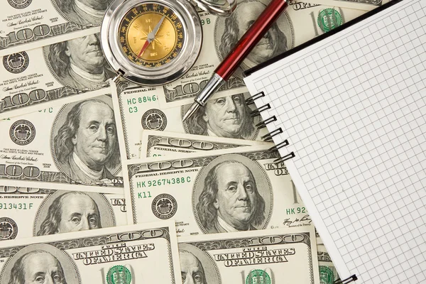 Pen, compass and notebook on dollars — Stock Photo, Image