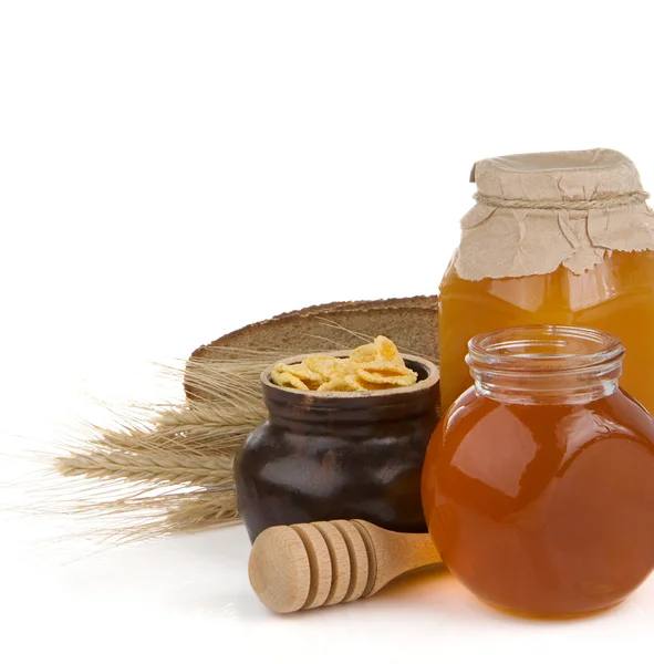 Glass pot full of honey and bread isolated — Stock Photo, Image