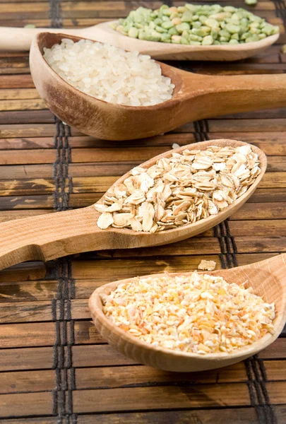 Reis, Erbsen und Hafer in einem Löffel auf dem Tisch — Stockfoto