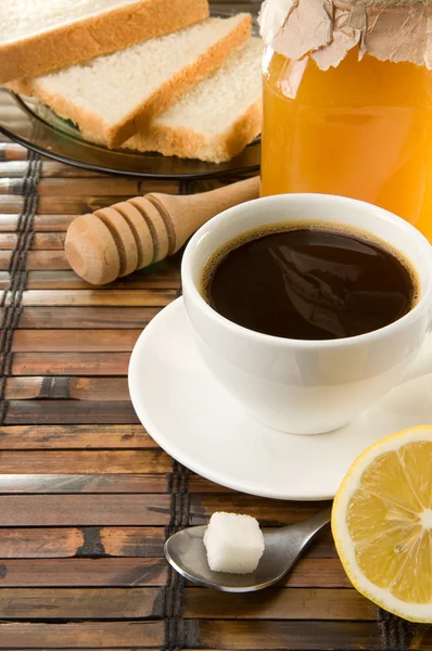 Kahvia, hunajaa ja leipää pöydällä — kuvapankkivalokuva