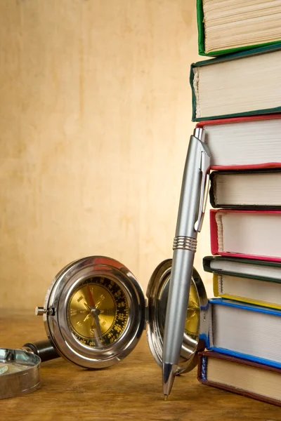 Hromadu knih a pera na dřevo — Stock fotografie