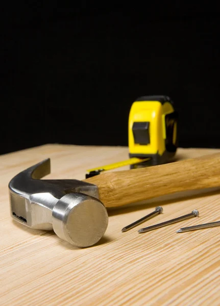 Martillo y cinta métrica en madera —  Fotos de Stock