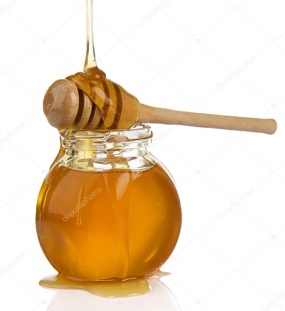 Glass pot full of honey and stick on white