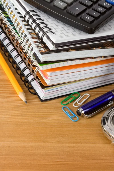 Stapel van notebook en pennen op hout achtergrond — Stockfoto