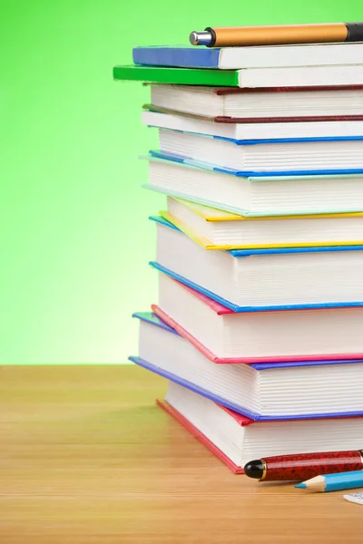 Stapel boeken en pen op groen — Stockfoto
