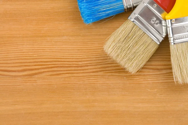 Colorful paintbrush on wood background — Stock Photo, Image