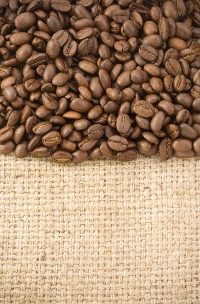 Coffee beans on hessian sack — Stock Photo, Image