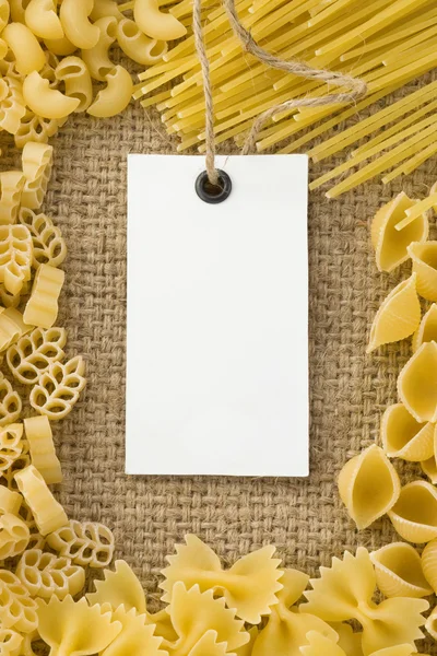 Ruwe pasta en prijskaartje op zak Hessiaan — Stockfoto