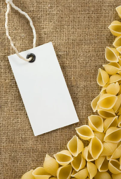 Pasta cruda y etiqueta de precio en saco arpillera hessian — Foto de Stock