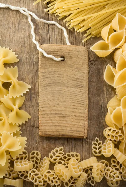 Raw pasta and price tag on woo — Stock Photo, Image