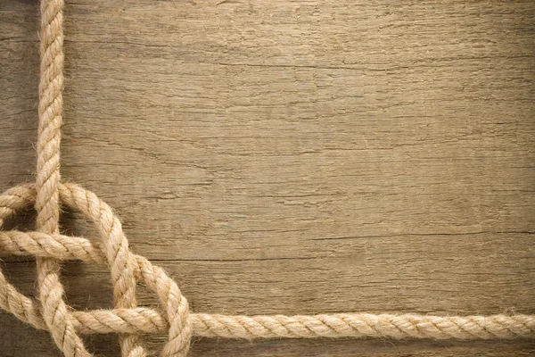 Cuerdas de barco con nudo sobre fondo de madera — Foto de Stock
