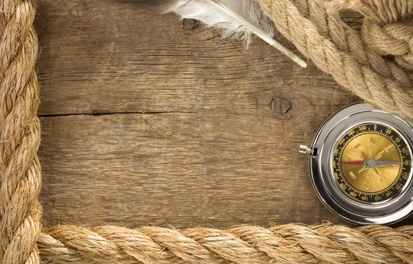 船舶绳索和指南针与在木材上的羽毛 — 图库照片