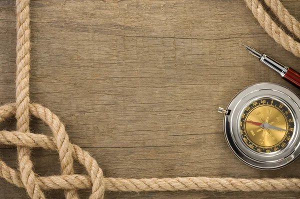 Schiffsseile und Kompass an altem Holz — Stockfoto