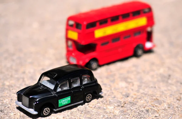 Объекты - Classic London Toy Red Double Decker Bus and Black Tax — стоковое фото