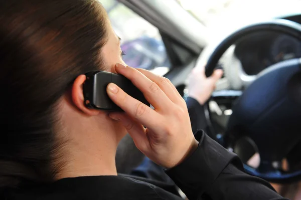 Молодая женщина в машине разговаривает по мобильному телефону — стоковое фото