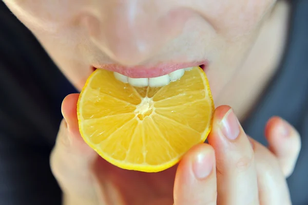 Lány eszik savanyú citrom — Stock Fotó