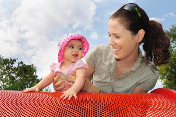 Bebê menina joga com a mãe no parque infantil — Fotografia de Stock