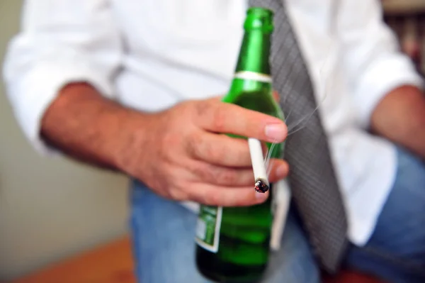 Рабочий курит сигарету и пьет пиво — стоковое фото