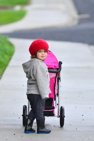 Kleines Mädchen mit Kinderwagen — Stockfoto
