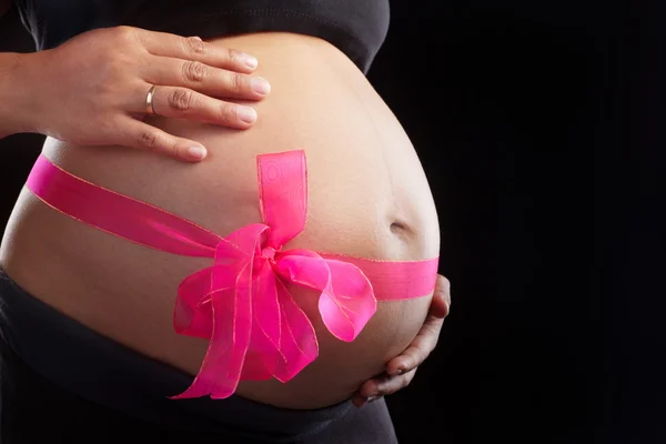 Schwangerschaft und rosa Schleife — Stockfoto