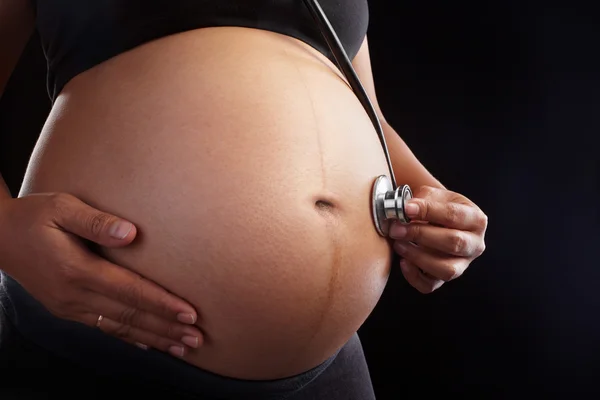 Pregnancy and stethoscope — Stock Photo, Image