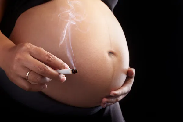 Беременность и курение — стоковое фото