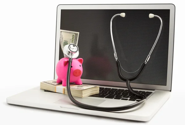 Piggy bank met stethoscoop op laptop — Stockfoto