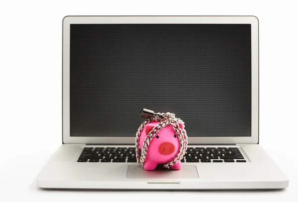 Chanined piggy bank on laptop — Stock Photo, Image