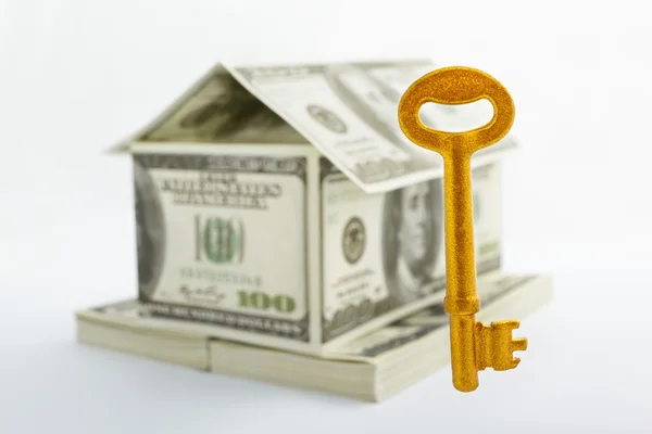 Casa em forma de dólares e chave dourada — Fotografia de Stock