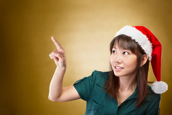 Flicka med santa hatt pekar bort — Stockfoto