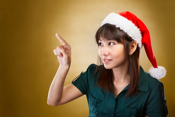 Menina com chapéu de Papai Noel apontando para longe — Fotografia de Stock
