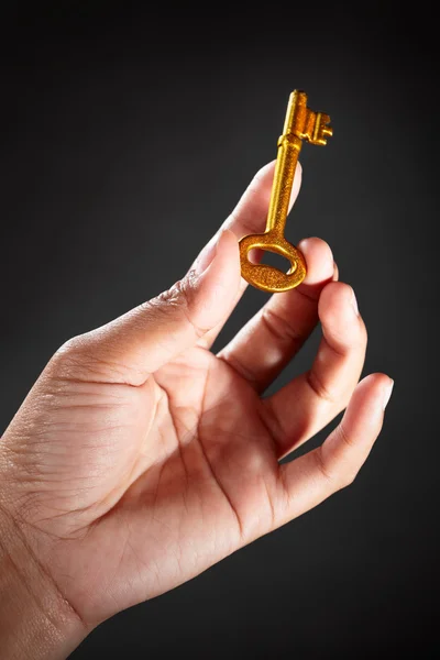 Рука тримає золотий ключ — стокове фото