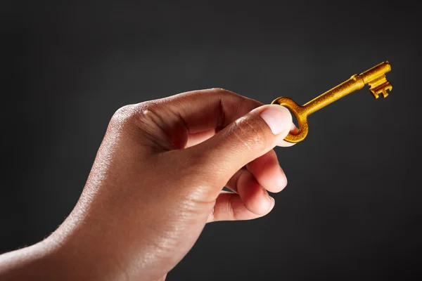 Hand holding golden key — Stock Photo, Image