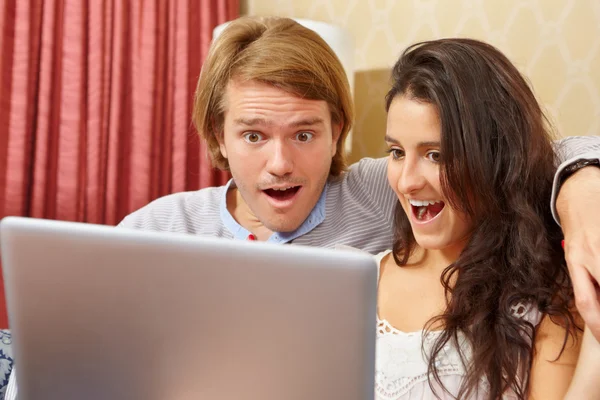Casal chocado com seu laptop — Fotografia de Stock
