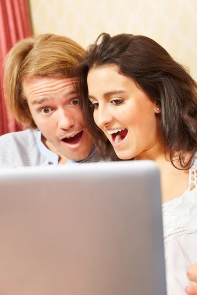 Шокированная пара со своим ноутбуком — стоковое фото