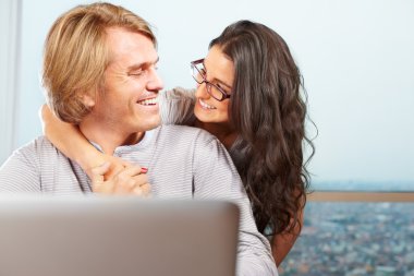 Happy couple in front of laptop clipart