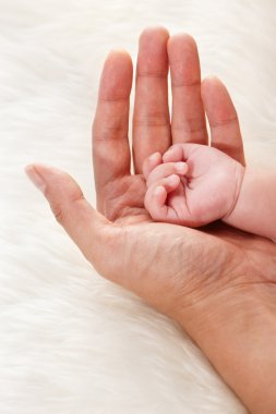 Baby's hand on father's palm clipart