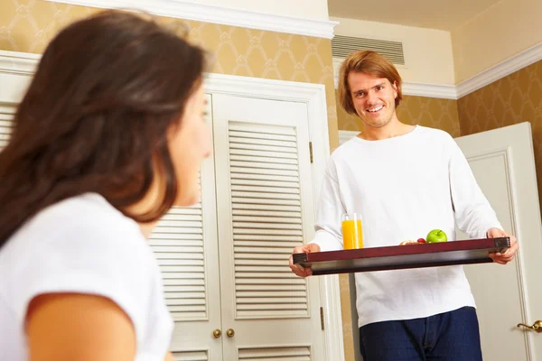 Człowiek dostarczający śniadanie do jej małżonka w łóżku — Zdjęcie stockowe