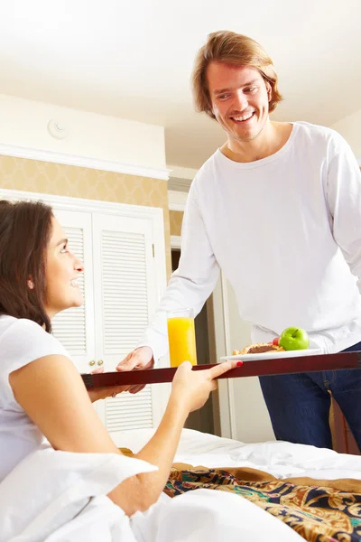 Człowiek dostarczający śniadanie do jej małżonka w łóżku — Zdjęcie stockowe