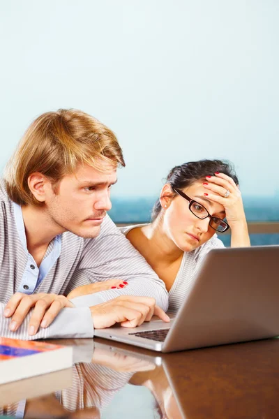 Casal deprimido na frente do laptop — Fotografia de Stock
