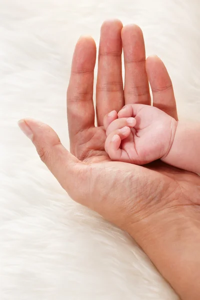 Baby's hand op vaders palm — Stockfoto
