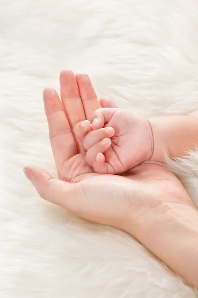 Рука ребенка на ладони матери — стоковое фото