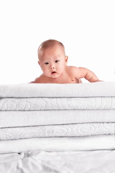 Bambino su mucchio di asciugamano — Foto Stock