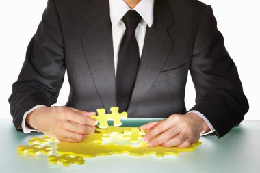 Businessman trying to finish the puzzle clipart