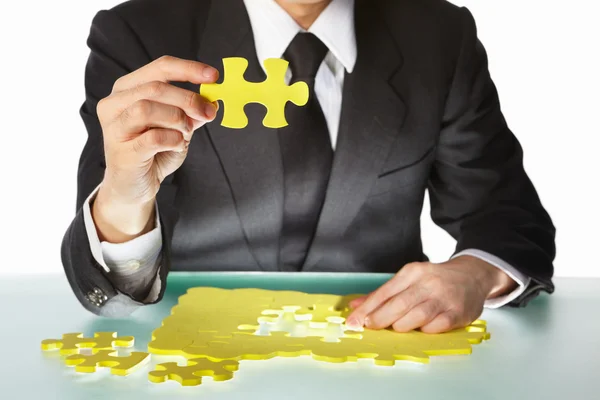 Empresário tentando terminar o quebra-cabeça — Fotografia de Stock