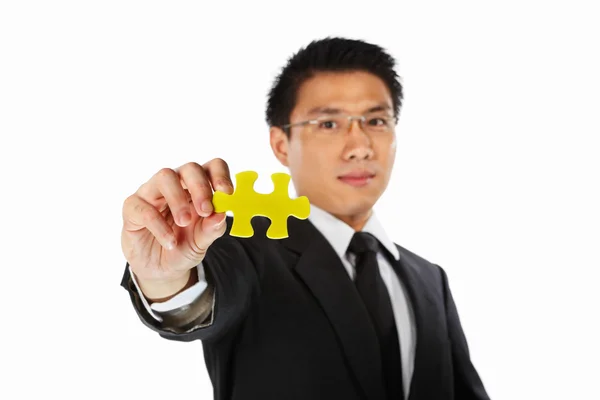 Businessman showing jigzaw puzzle piece — Stock Photo, Image