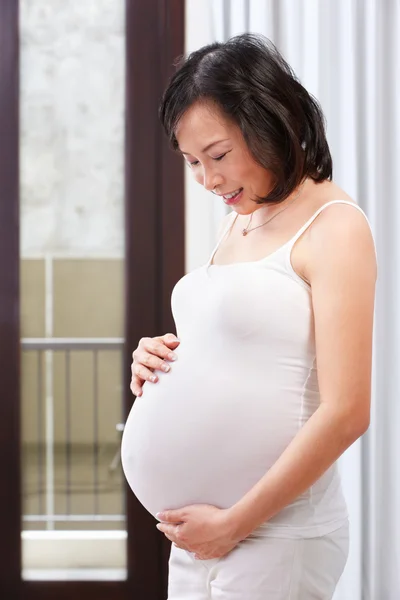 Senhora grávida acaricia seu estômago — Fotografia de Stock