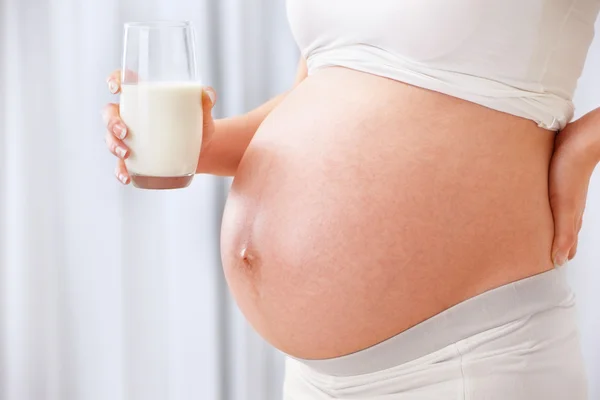 Mjölk och magen av gravid kvinna — Stockfoto