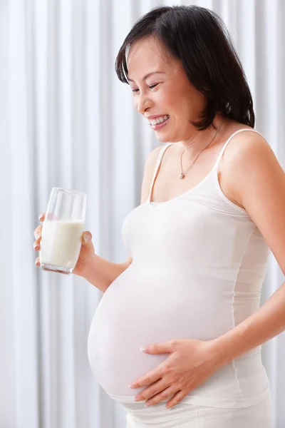 怀孕的女的拿一杯牛奶 — 图库照片